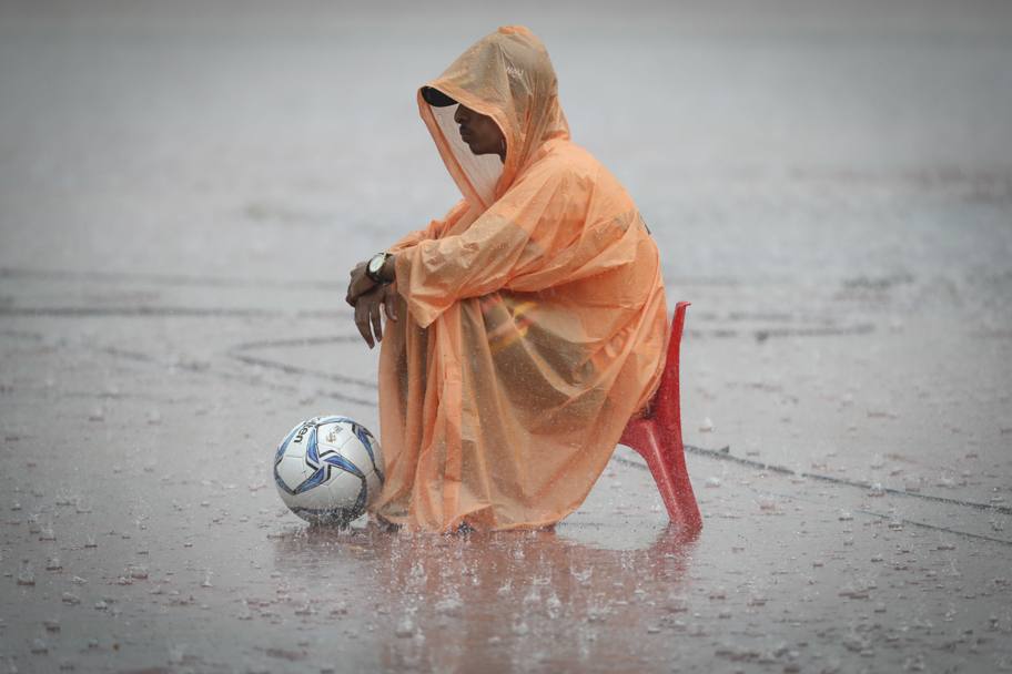 Selayang, Malesia, partita di apertura del torneo di calcio ai giochi del Sudest Asiatico: un raccattapalle seduto sotto la pioggia battente durante il match tra Singapore e Myanmar (Ap)